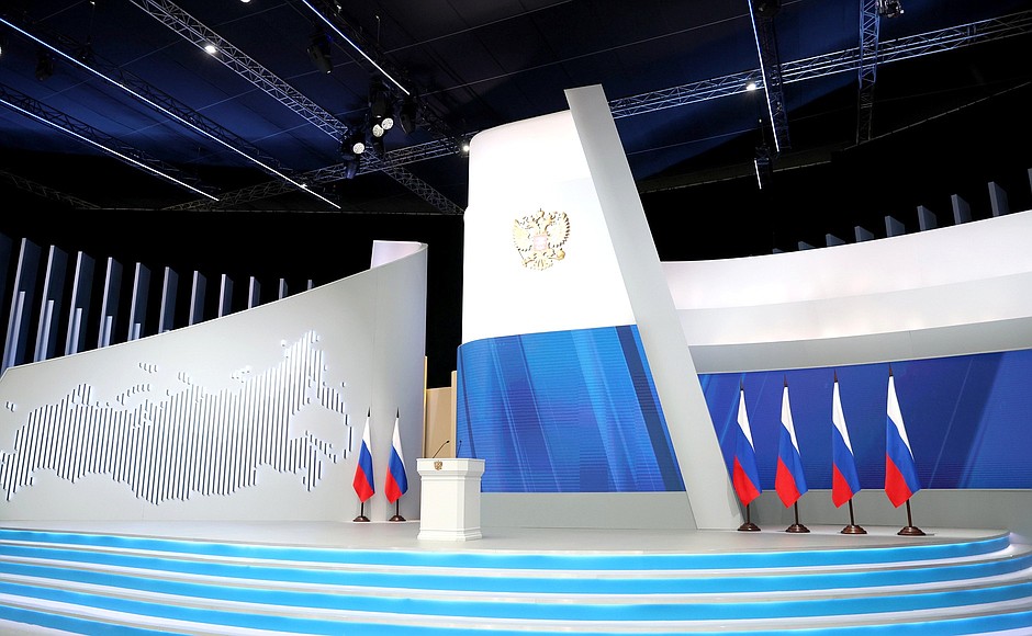 Empty podium on a stage set for a political speech, featuring national flags